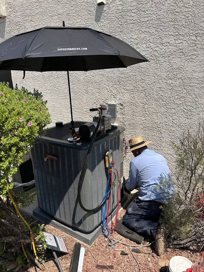 HVAC technician performing outdoor AC maintenance in Ferry Pass