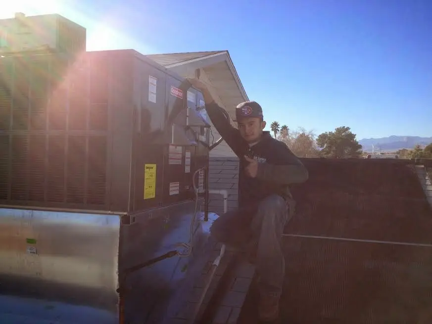 HVAC technician performing Air Duct Cleaning on a rooftop unit in Ferry Pass